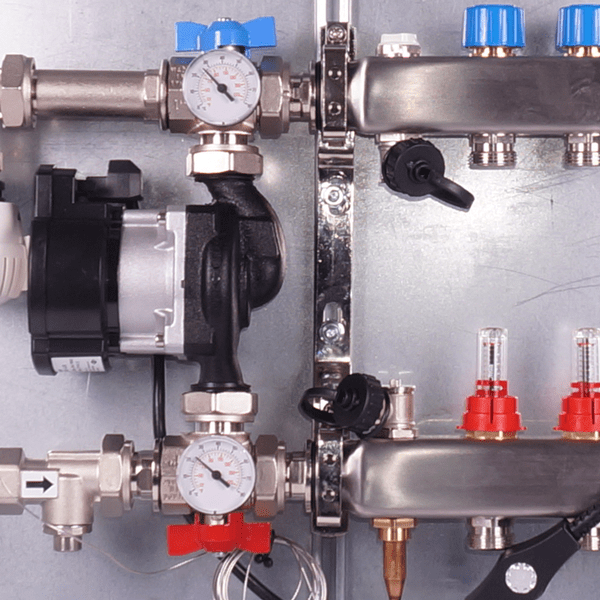 Heating pump with two pressure gauges, a thermostat valve, multiple blue and red valves, metal pipes, and connectors.