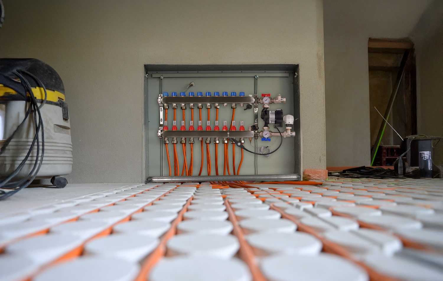 Heizungsverteiler für die Fussbodenheizung und installierte Fussbodenheizungsrohre